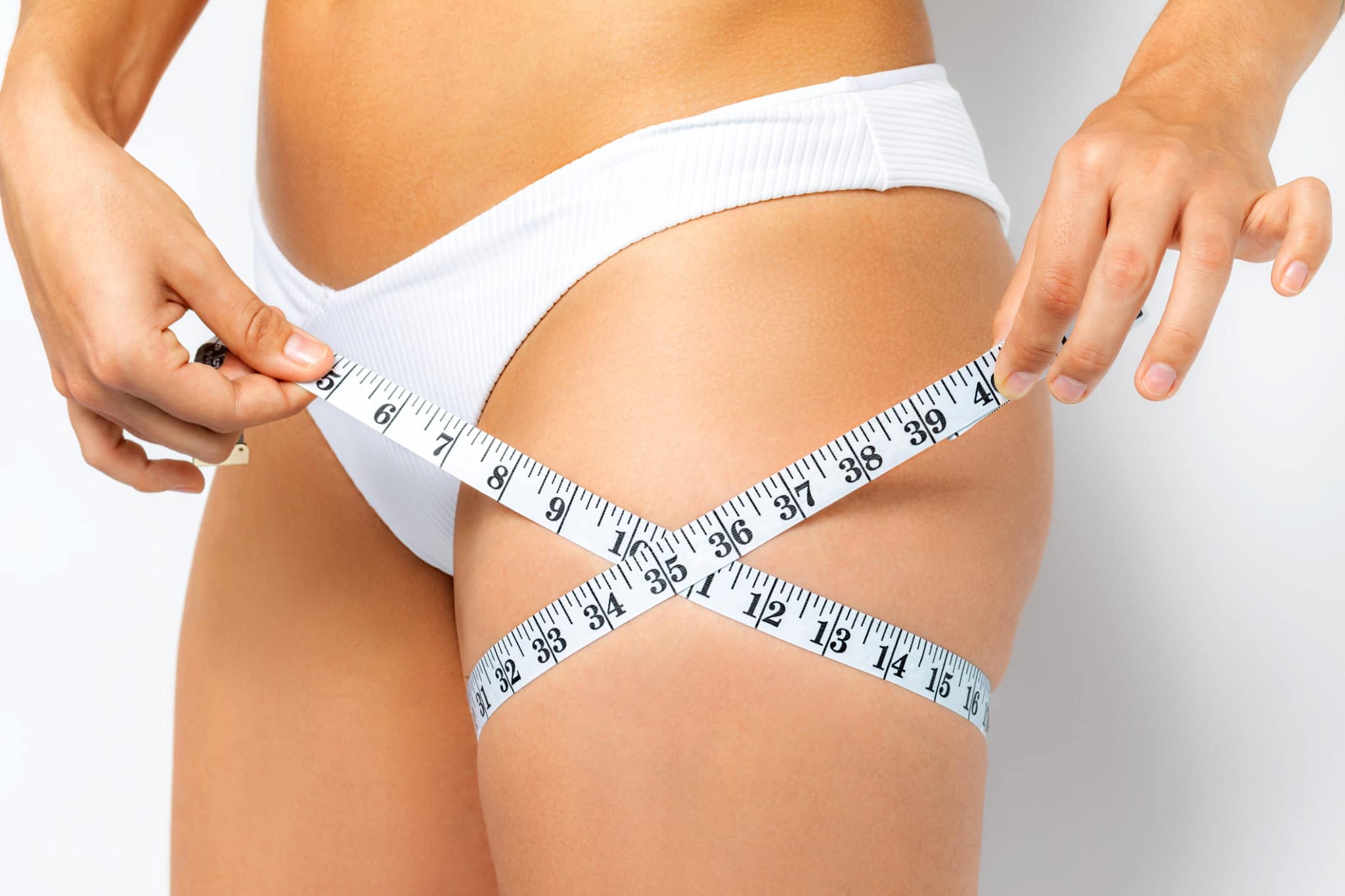 image of woman measuring thighs with a tape measure